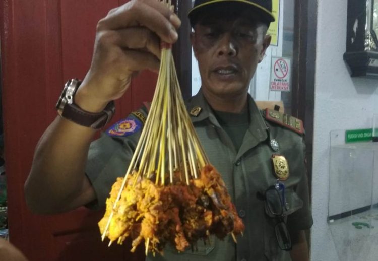 Petugas Satpol PP Kota Padang menunjukkan barang bukti sate yang diduga dari daging babi pada Selasa (29/1/2019)