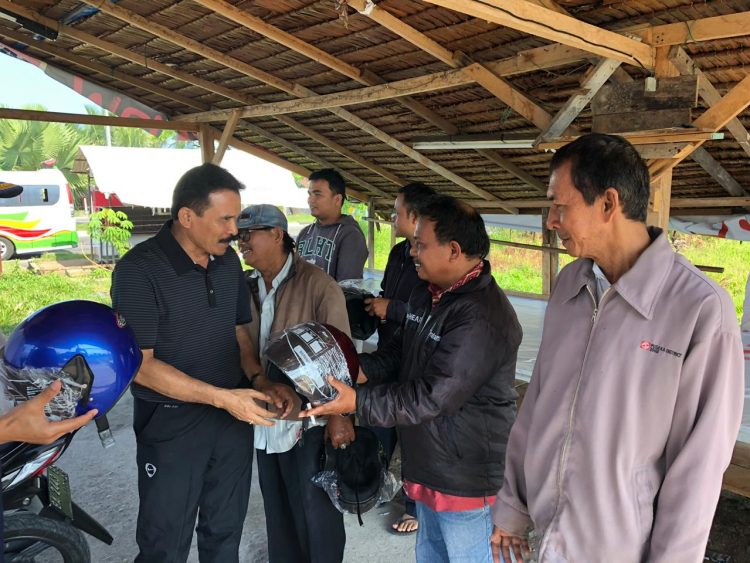 Kapolda Sumbar Irjen Pol Fakhrizal saat membagi-bagikan helm kepada tukang ojek dan pengendara motor di Padang (ist)