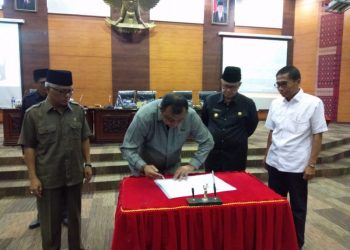 Ketua DPRD Sumbar Hendra Irwan Rahim menandatangani Perda Ketenagakerjaan. (Foto: Humas DPRD Sumbar)