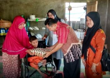 Dinas Sosial PP & PA Kabupaten Sijunjung menyerahkan bantuan makanan tambahan bergizi untuk salah seorang anak penyandang disabiltas di daerah itu (Foto: Humas Pemkab Sijunjung)