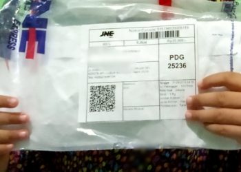 Seorang anak di Padang menerima paket kiriman melalui jasa JNE yang pesan ibunya (Foto: Riki Chandra)