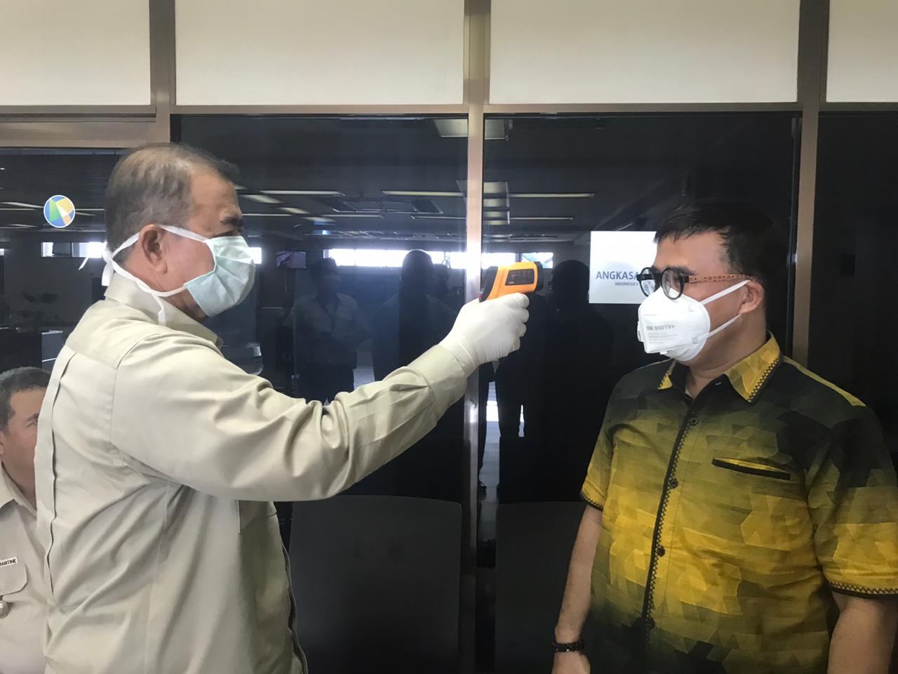 Wakil Gubernur Sumbar Nasrul Abit saat mencoba memeriksa penumpang Bandara Internasional Minangkabau (BIM) dengan alat thermo gun, Senin (16/3/2020). (Foto: Humas Pemprov Sumbar)