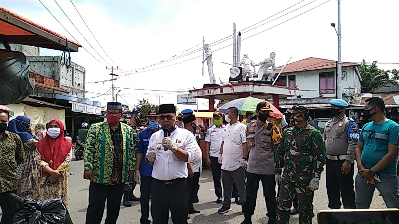 Tim Satgas bersama TNI dan Polri melakukan sosialisasi menjelang pelaksanaan new normal di Pasar Simpang Tiga, Kabupaten Pasaman Barat. (Foto: Iyan)