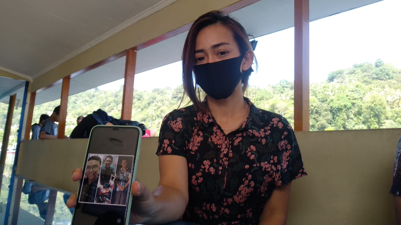 Regina, anak salah seorang korban kapal karam memperlihatkan tiga foto korban yang hilang akibat kapal karam. Orang tua regina bernam Ridwan Gazali merupakan penyelamat para pemancing. (Foto: Irwanda)