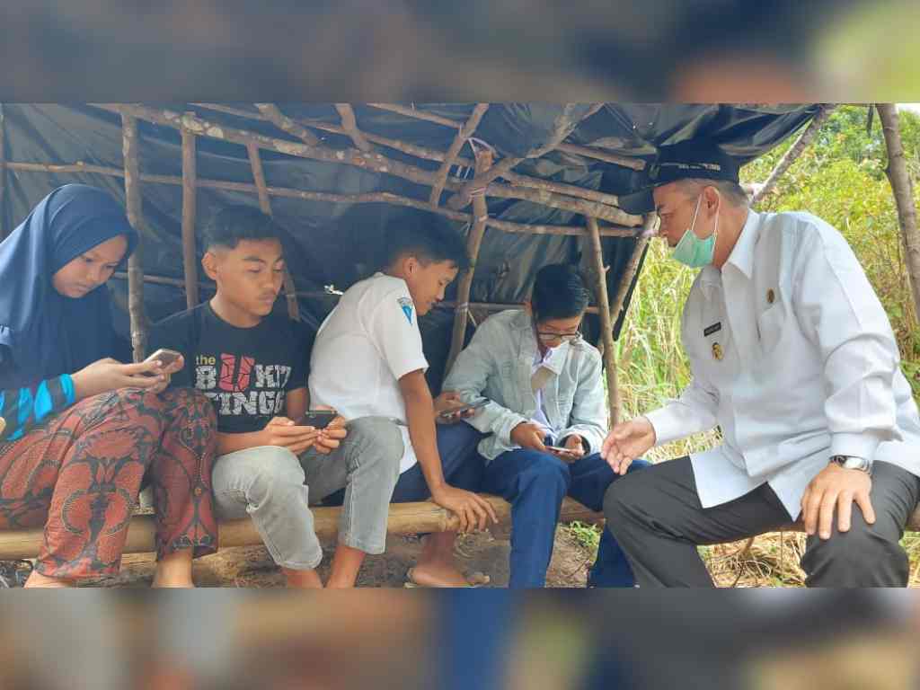Wagub Sumbar Nasrul Abit ketika berbincang dengan pelajar yang mencari sinyal ke puncak bukit di Kecamatan Palupuah, Kabupaten Agam. (Foto: Dok.Humas Pemprov Sumbar)