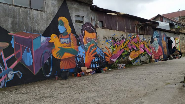 Aksi seniman mural di Padang. (Ldi/langgam.id)