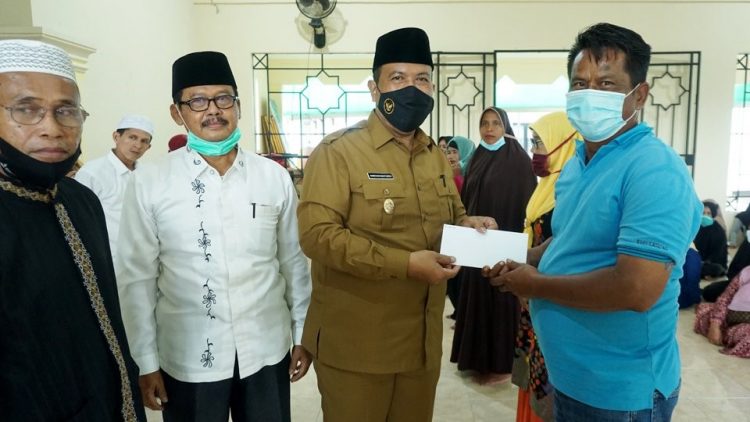 Plt Wako Pariaman Mardison Mahyuddin menyerahkan zakat ASN lewat Baznas ke pelaku UMKM. (Foto: dok humas)