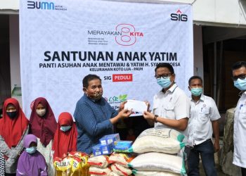 Kepala Unit CSR Semen Padang Muhammad Ikrar (kanan) menyerahkan bantuan tali asih anak yatim  dari SIG kepada Pimpinan Panti Asuhan H. Syafri Moesa, Safirdaus (kiri), Selasa, 29 Desember 2020. (Foto: dok humas SP)
