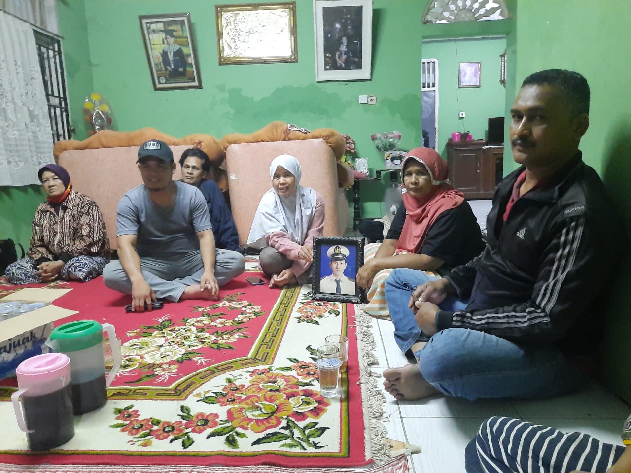 Ibunya Afrida memperlihatkan foto Angga Fernanda Afriyon salah satu penumpang pesawat Sriwijaya Air yang terjatuh di Padang. (Foto: Rahmadi/Langgam.id)