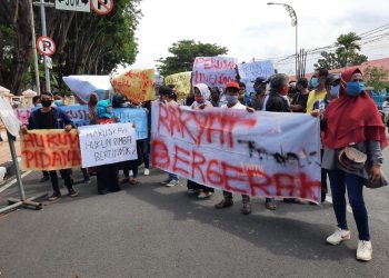 Para peserta demo membawa spanduk-spanduk saat menggelar aksi di depan Kantor Gubernur Sumbar. (foto: Rahmadi/Langgam.id)