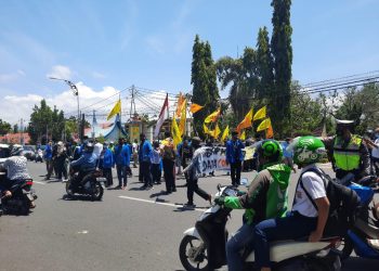 Peserta aksi berkumpul di tengah jalan di depan Kantor Gubernur Sumbar. (foto: Rahmadi/Langgam.id)