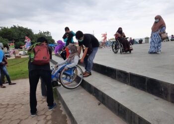 HWDI Sumbar mencoba fasilitas yang ada di Pantai Padang menggunakan kursi roda. (foto: Rahmadi/langgam.id)