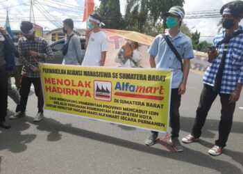 Puluhan massa melakukan aksi demonstrasi di depan Kantor Gubernur Sumbar menolak kehadiran Alfamart, Senin (7/6/2021). (foto: Rahmadi/langgam.id)