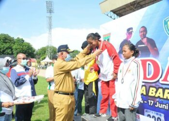 Gubernur Sumbar Mahyeldi mengalungan medali kepada kepada atlet yang berhasil memenangkan perlombaan pada Pekan Olahraga Pelajar Daerah (POPDA). (foto: Humas Pemprov Sumbar)