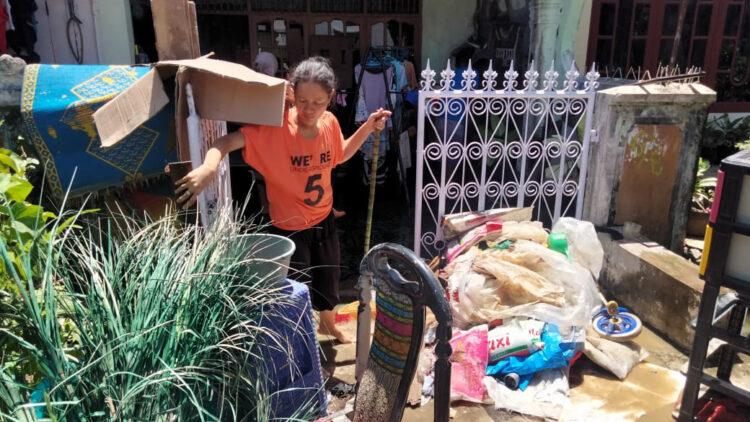 Warga Padang bersihkan rumah dari sisa banjir. [foto: Irwanda/langgam.id]