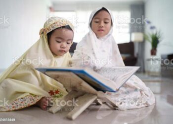 portrait of adorable muslim young kid read quran together at home