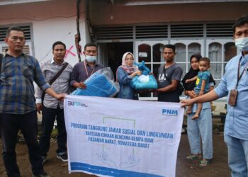 Pemimpin PNM Cabang Padang Yulia Vitria Yohannes (tengah) menyerahkan bantuan tahap dua kepada nasabah korban gempa di Pasaman Barat. (Foto: dok PNM Padang)
