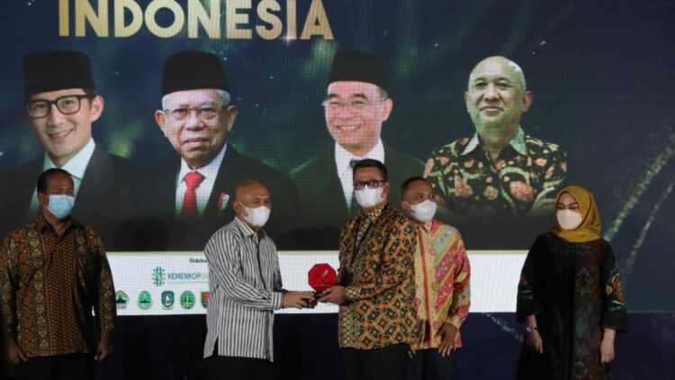 Menteri Koperasi dan UKM Teten Masduki menyerahkan penghargaan untuk PT PNM dalam acara Merdeka Award yang diterima oleh Executive Vice President Bisnis PT PNM Sasono Hartarto, Kamis (30/6/2022). (Foro: Ist)