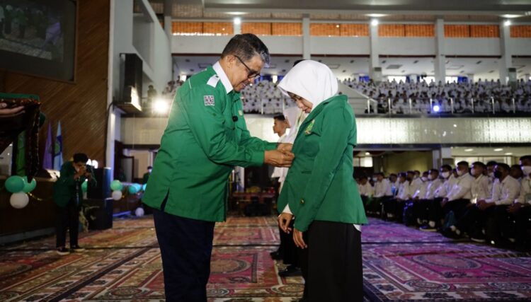Rektor Unand Prof. Dr. Yuliandri, SH. MH memasangkan jaket almamater kepada mahasiswa baru secara simbolis menandai dimulainya kegiatan PPKMB Unand 2022. (Foto: Humas Unand)