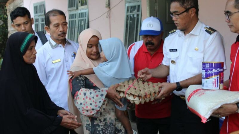 Pj. Wali Kota Payakumbuh Rida Ananda menyerahkan bantuan sembako berupa telur, susu dan beras, kepada warga miskin di Kelurahan Payobasung