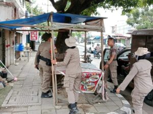 Satpol PP Kota Padang melakukan penertiban sejumlah lapak pedagang yang berjuaalan di atas trotoar dan bahu jalan pada Senin (6/11/2023).