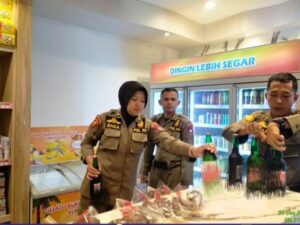 Satpol PP Padang mengamankan sejumlah botol minuman beralkohol dari sebuah mini market di Kecamatan Padang Selatan, Jumat (29/12/2023).