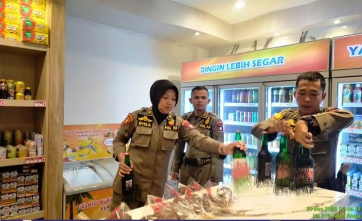 Satpol PP Padang mengamankan sejumlah botol minuman beralkohol dari sebuah mini market di Kecamatan Padang Selatan, Jumat (29/12/2023).