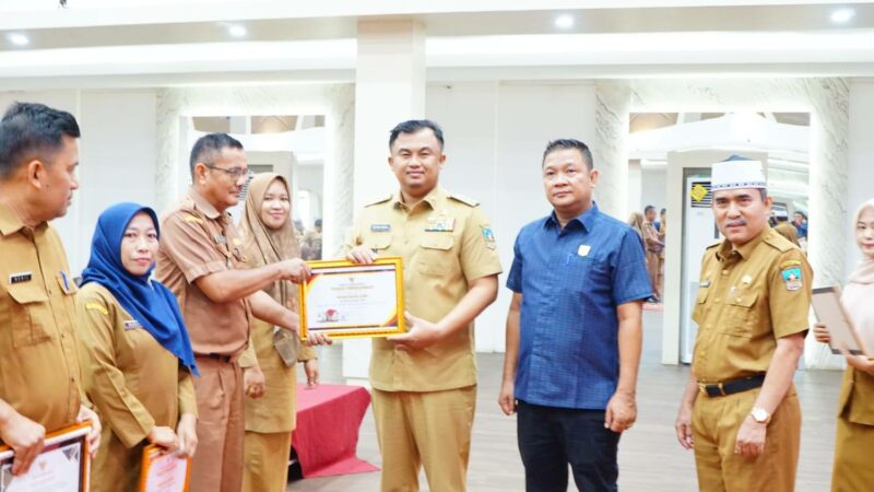 Bupati Dharmasraya, Sutan Riska Tuanku Kerajaan menyerahkan piagam penghargaan pengawasan kearsipan internal Pemkab Dharmasraya tahun 2024.