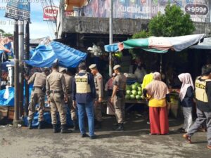 Satpol PP Padang menertibkan pedagang yang masih berjualan di trotoar dan badan jalan di Pasar Lubuk Buaya, Kecamatan Koto Tangah,