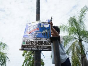 Pemko Padang menertiban sejumlah spanduk, baliho dan papan nama usaha yang ada sejak Senin (8/9/2025). Media promosi luar ruang itu .